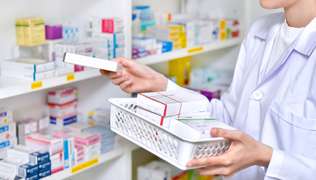 Pharmacist searching for products on his pharmacy shelves