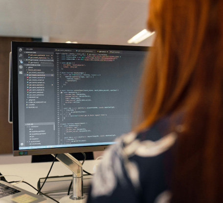 Developer working on computer code on screen
