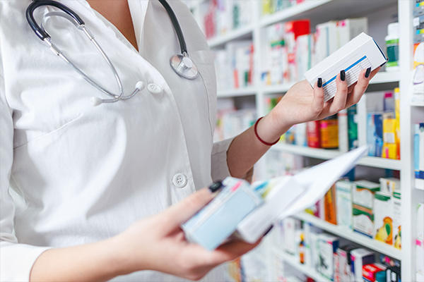 Healthcare professional examining medication boxes in a pharmacy