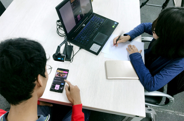 Designer UX menant un test d'utilisabilité avec un participant sur tablette, validant un prototype d'application numérique