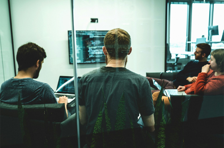 Équipe de développement collaborant avec un designer UI UX lors d'une présentation de prototypes en atelier